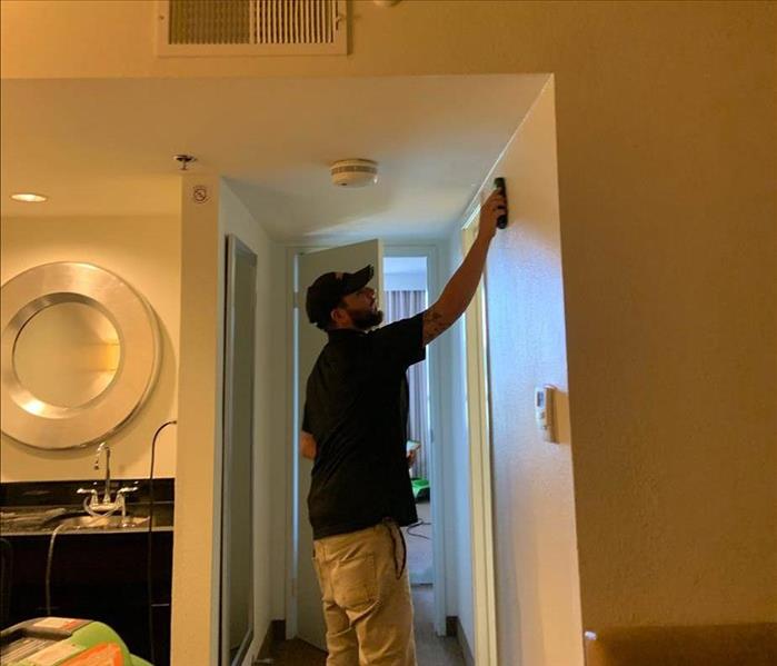 SERVPRO team member using advanced technology to check moisture levels.