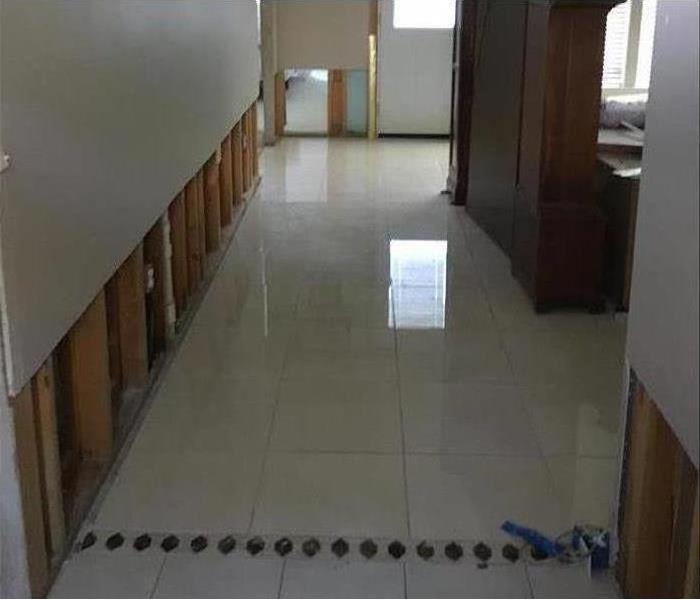 Wet floor, clear water standing on white flooring, flood cuts performed on drywall
