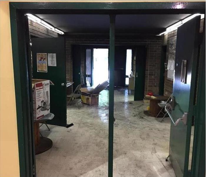 Door of a business open, wet floor, boxes on floor. Concept of a storm caused water damage to building